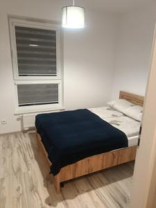 ein kleines Schlafzimmer mit einem Bett und einem Fenster in der Unterkunft Apartament Rumia z Garażem in Rumia
