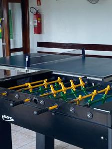 un tavolo da ping pong con una palla da ping pong di Apartamento Pé na Areia a Caraguatatuba
