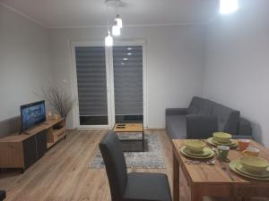 ein Wohnzimmer mit einem Tisch und einem Sofa in der Unterkunft Apartament Rumia z Garażem in Rumia