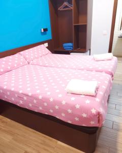 1 dormitorio con 1 cama con sábanas rosas y estrellas en corazón San Bartolomé, en Madrid