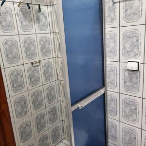 a shower with a blue door in a bathroom at Apartamento Pé na Areia in Caraguatatuba
