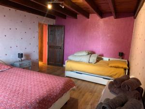 sypialnia z 2 łóżkami i różową ścianą w obiekcie Le Gîte de Félix - Maison chaleureuse 190m2 - 6 ch - 20pers w mieście Sonnay