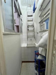 Baño pequeño con escalera y lavabo en Apartamento Top em Copacabana- Rio de Janeiro., en Río de Janeiro