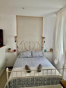 a bedroom with a large bed with a metal headboard at La casita de San Andrés in Seville