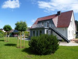 una casa con techo rojo y escalera en Amandas Nest, en Zingst