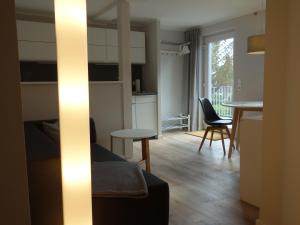 ein Wohnzimmer mit Küche und Tisch und Stühlen in der Unterkunft Amandas Nest in Zingst