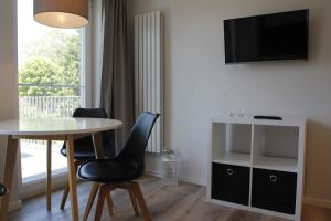 ein Wohnzimmer mit Tisch und Stühlen und einem Fenster in der Unterkunft Amandas Nest in Zingst