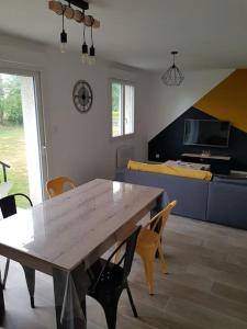 ein Esszimmer mit einem Holztisch und Stühlen in der Unterkunft Le clos du rhododendron proximité Dieppe in Le Bois-Robert