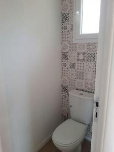 uma casa de banho com um WC branco e uma janela em Le clos du rhododendron proximité Dieppe 