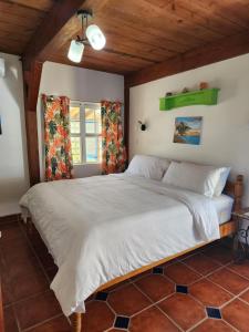 um quarto com uma grande cama branca num quarto em The BNB on Triggerfish Close to the airport em Ladyville