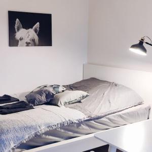 uma cama num quarto branco com uma fotografia de um cão em New studio Blue near Helsinki airport in Kivistö em Vantaa