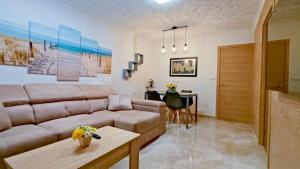 ein Wohnzimmer mit einem Sofa und einem Tisch in der Unterkunft CASA SOLEADA. Intimidad, piscina y mucho sol. in Santiago de la Ribera