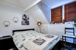 a bedroom with a bed and a window and a chair at Entire Artistic Open-Plan Top Floor Apartment in Westcliff-On-Sea