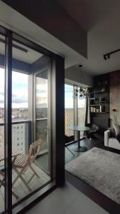 a living room with a balcony with a table and chairs at Hanza Tower Studio in Szczecin