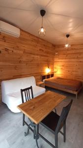 Habitación con 2 camas, mesa de madera y sillas. en Le chalet de La Treille en Marsella