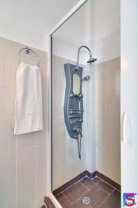 a bathroom with a shower with a mirror and a towel at Soultana Rooms & Studios in Pollonia