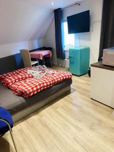 een kamer met een bed en stoelen en een televisie bij Hotel Waldhorn in Stuttgart