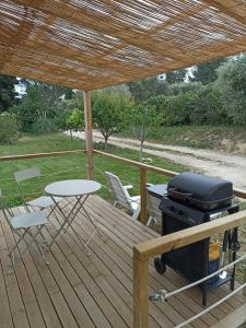 a grill on a wooden deck with a table and chairs at Le chalet de La Treille in Marseille