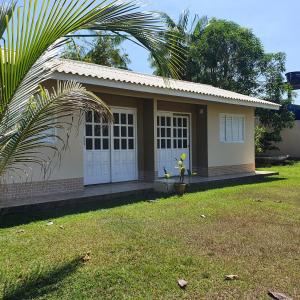 a small house with a palm tree in front of it at Casa Bouganville apto triplo in Novo Airão