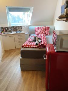 Habitación pequeña con cama con almohada roja y blanca en Hotel Waldhorn, en Stuttgart