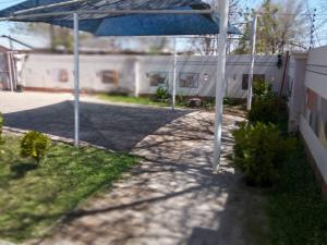 patio z niebieskim parasolem na dziedzińcu w obiekcie Chiloto Guest House w mieście Kasane