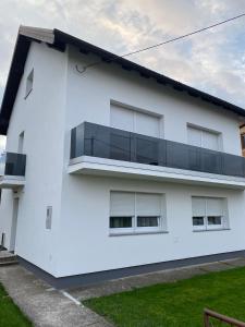 a white house with a balcony at Imperium Rooms Zagreb Airport in Velika Gorica