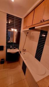 a bathroom with a bath tub and a sink at Ola Blanca Sidi rahal Apparthotel in Sidi Rahal