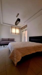 a bedroom with a large bed and a couch at Ola Blanca Sidi rahal Apparthotel in Sidi Rahal