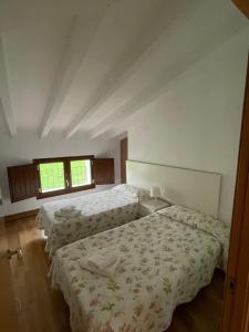 1 dormitorio con 2 camas y 2 ventanas en Compuerta Otañes, en Otañes