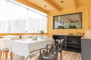 a dining room with a white table and chairs at Premium Eco Chalet 1888 in Bad Sankt Leonhard im Lavanttal
