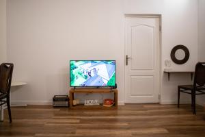 a flat screen tv sitting on a stand in a living room at Interbelic house with courtyard and terrace in Bucharest