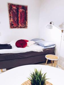 a bedroom with a bed with a painting on the wall at New Studio Cherry near Helsinki airport in Kivistö in Vantaa