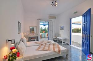 a white bedroom with a bed and a living room at Soultana Rooms & Studios in Pollonia