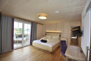 a bedroom with a bed and a desk and a television at Gasthaus Reiter in Pinsdorf