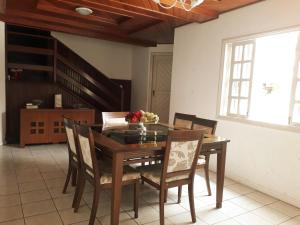 uma sala de jantar com uma mesa de madeira e cadeiras em Casa de praia / piscina em Santa Cruz Cabrália