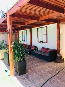 a covered patio with couches and a potted plant at Casa con Piscina privada en Pica in Iquique