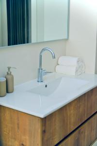 um balcão de casa de banho com um lavatório e um espelho em 10 min from Hilton Beach with free parking em Ramat Gan