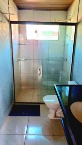 uma casa de banho com um chuveiro, um WC e um lavatório. em Chaleville Coqueiro 3202 - Luis Correia Piauí em Luís Correia