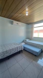 um quarto com duas camas e uma janela em Chaleville Coqueiro 3202 - Luis Correia Piauí em Luís Correia