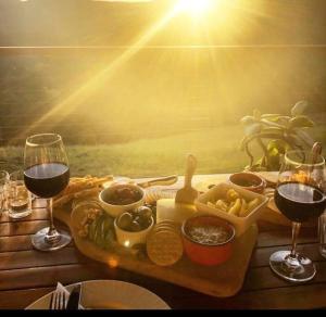 una mesa con una bandeja de comida y dos copas de vino en Black Wattle Cabin Turon Escape Capertee en Capertee