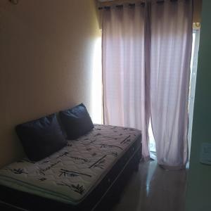 1 cama en una habitación con ventana en Condomínio Villamares en Luis Correia