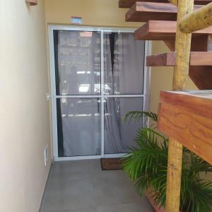 a sliding glass door to a patio with a plant at Condomínio Villamares in Luis Correia