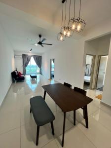 een eetkamer en een woonkamer met een tafel en stoelen bij Spacious Family Staycation 3BR at Ipoh Uptown in Ipoh