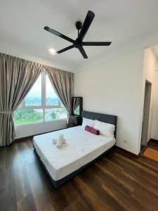 een slaapkamer met een groot bed en een plafondventilator bij Spacious Family Staycation 3BR at Ipoh Uptown in Ipoh