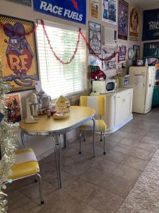 eine Küche mit einem Tisch und Stühlen sowie eine Küche mit Geräten in der Unterkunft My Oasis in Bakersfield