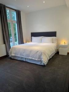 a bedroom with a large bed and a window at Designer 2 bedroom Pimlico in London