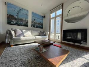 a living room with a couch and a tv and a table at Designer 2 bedroom Pimlico in London