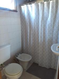 y baño con aseo y lavamanos. en Hostel Nakel Yenu en El Calafate