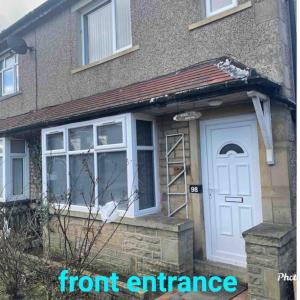 una entrada delantera de una casa con una puerta blanca en Cheerful 3 bed semi-detached property, en Bradford
