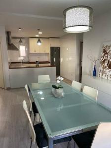 uma sala de jantar com uma mesa azul e cadeiras brancas em Lujoso y amplio apartamento en Crevillente em Crevillente